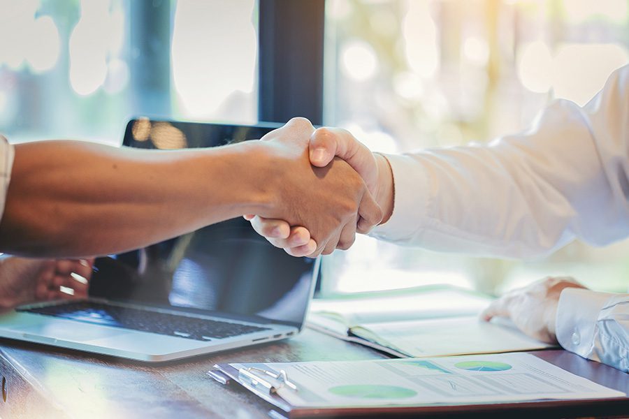 Buy-Sell Agreement - Two Business Partners Shake Hands After Completing Negotiations at an Office